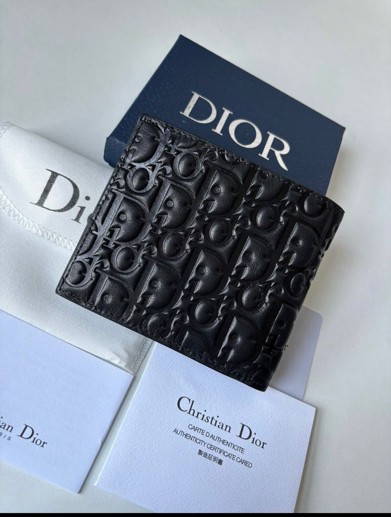 Dior bifold wallet crafted from black leather, featuring an embossed Dior Oblique or Dior Gravity motif