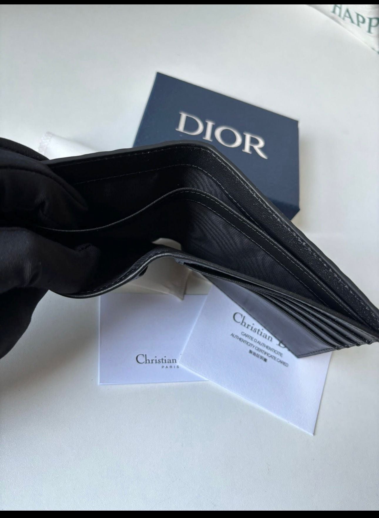 Dior bifold wallet crafted from black leather, featuring an embossed Dior Oblique or Dior Gravity motif