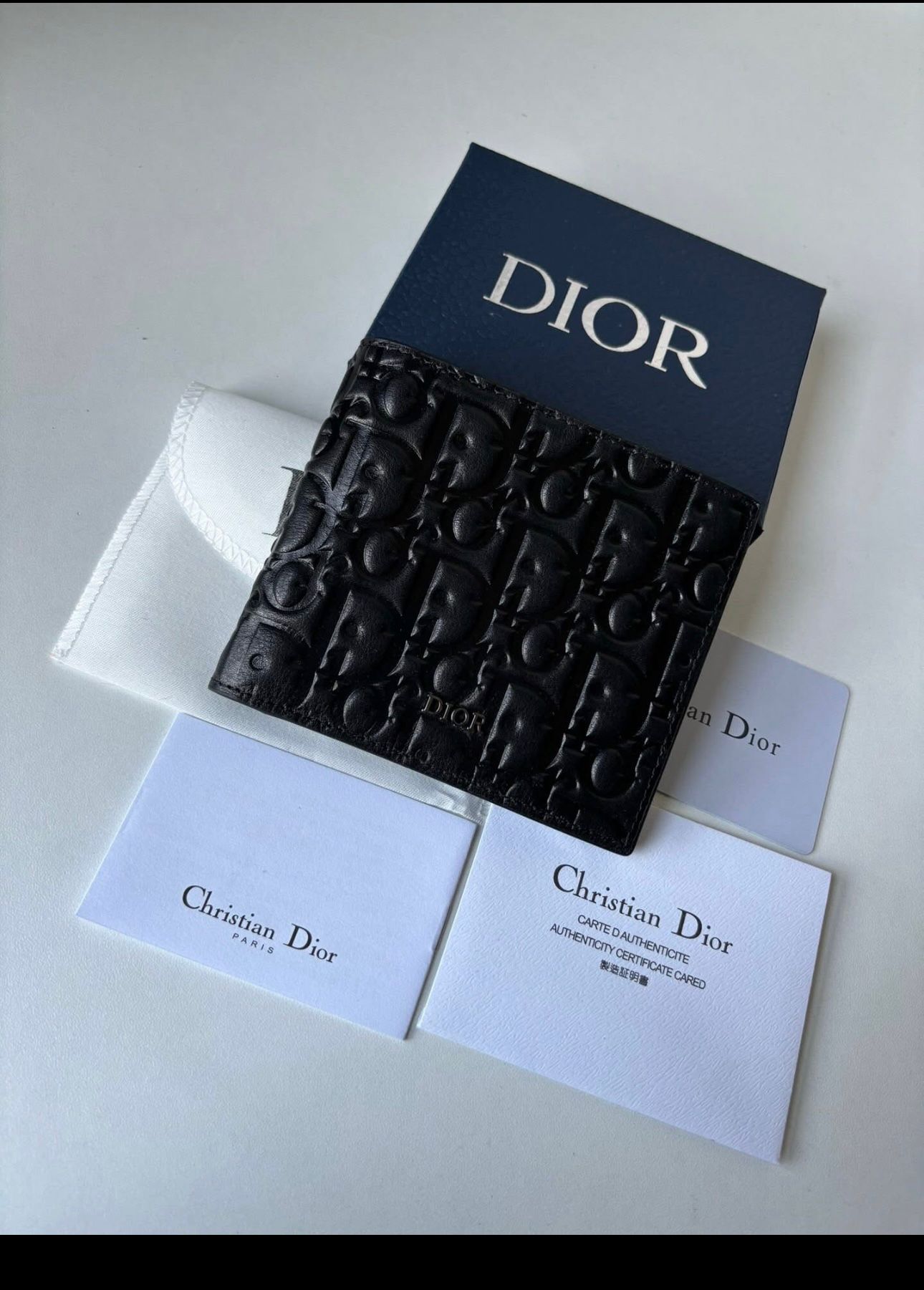 Dior bifold wallet crafted from black leather, featuring an embossed Dior Oblique or Dior Gravity motif