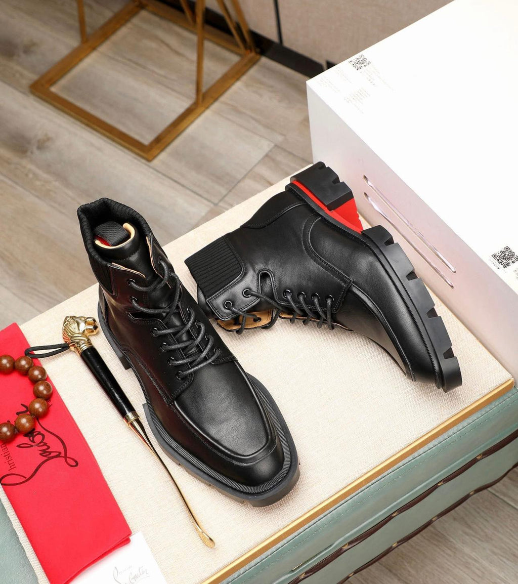 Christian Louboutin Trapman black calf leather ankle boot. It features a lug sole with the signature red lacquer bottom
