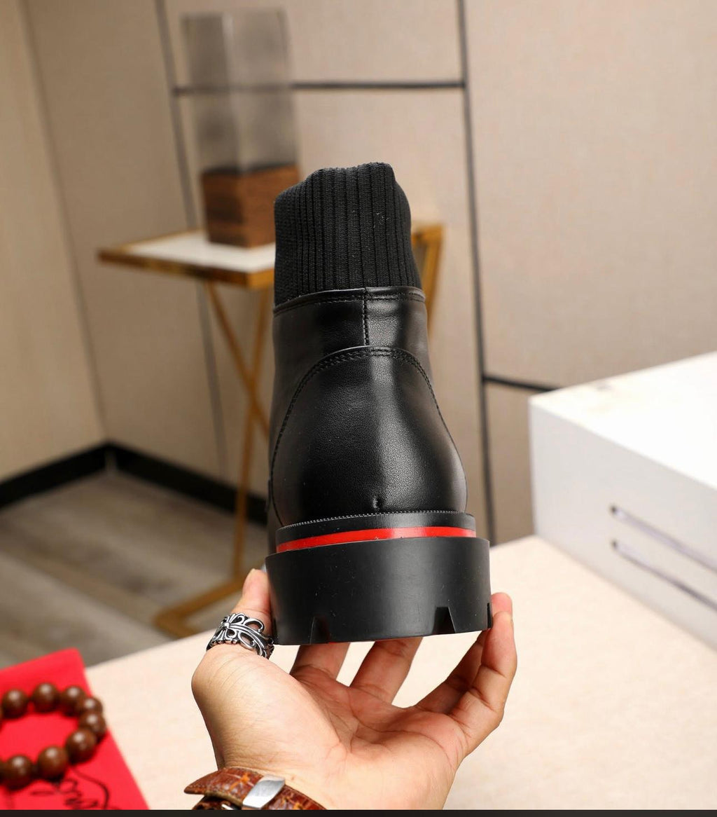 Christian Louboutin Trapman black calf leather ankle boot. It features a lug sole with the signature red lacquer bottom