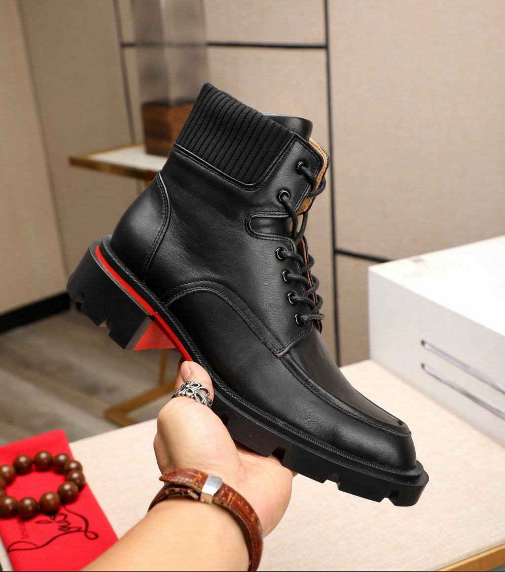 Christian Louboutin Trapman black calf leather ankle boot. It features a lug sole with the signature red lacquer bottom