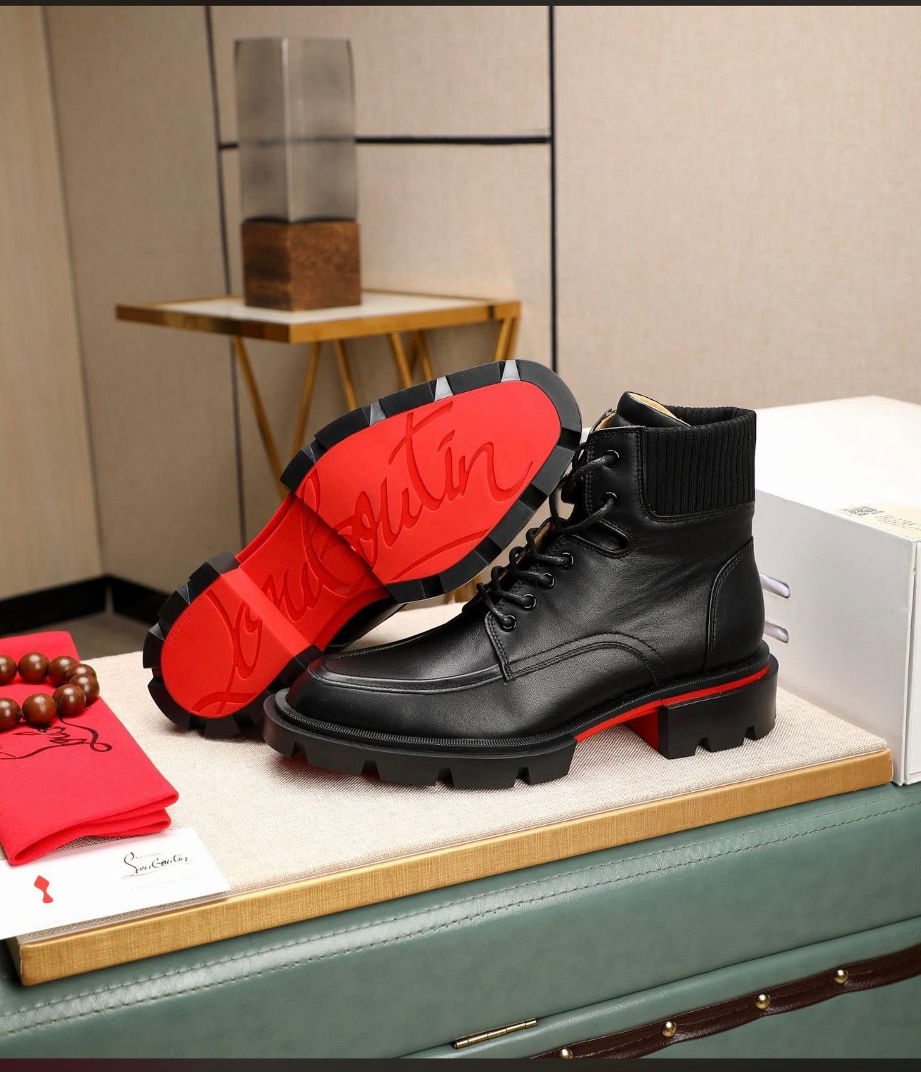 Christian Louboutin Trapman black calf leather ankle boot. It features a lug sole with the signature red lacquer bottom